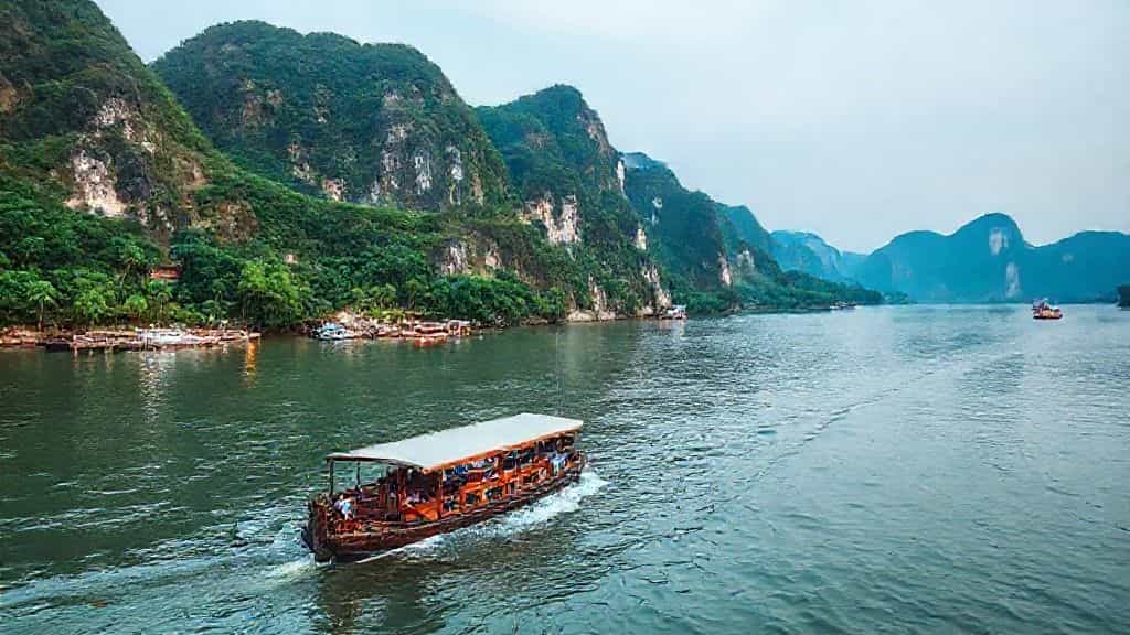 tour boat passing riverbank elephants on a mekong river cruise